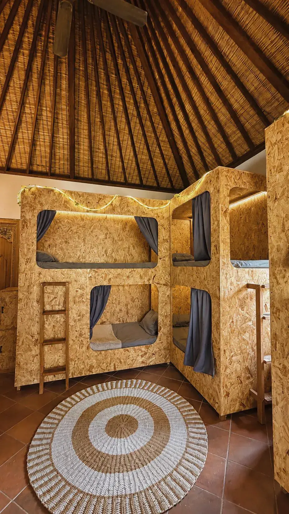 The 8-bed dorm, wooden pods under the thatched roof
