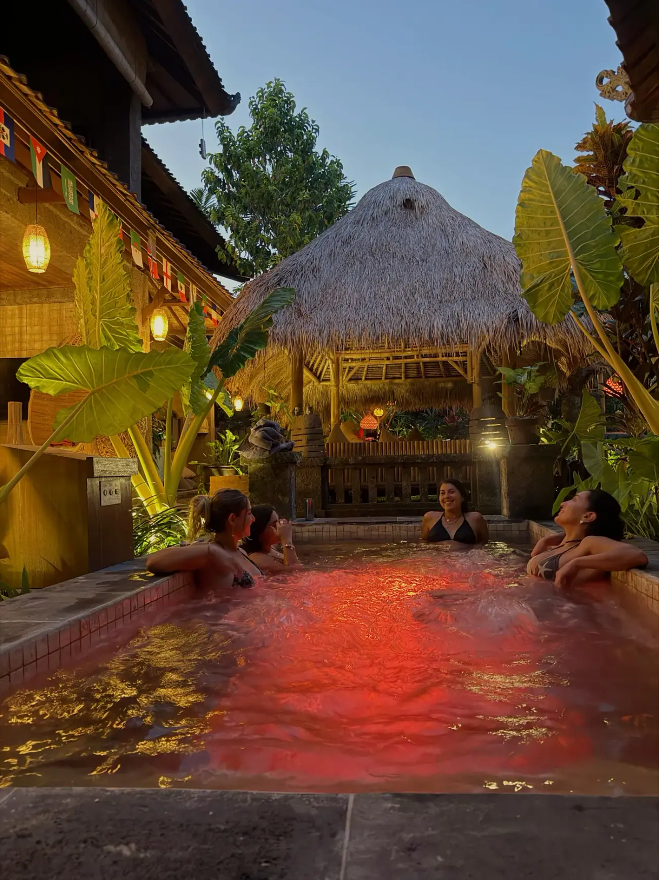 The jacuzzi at night under red light, guests in the water