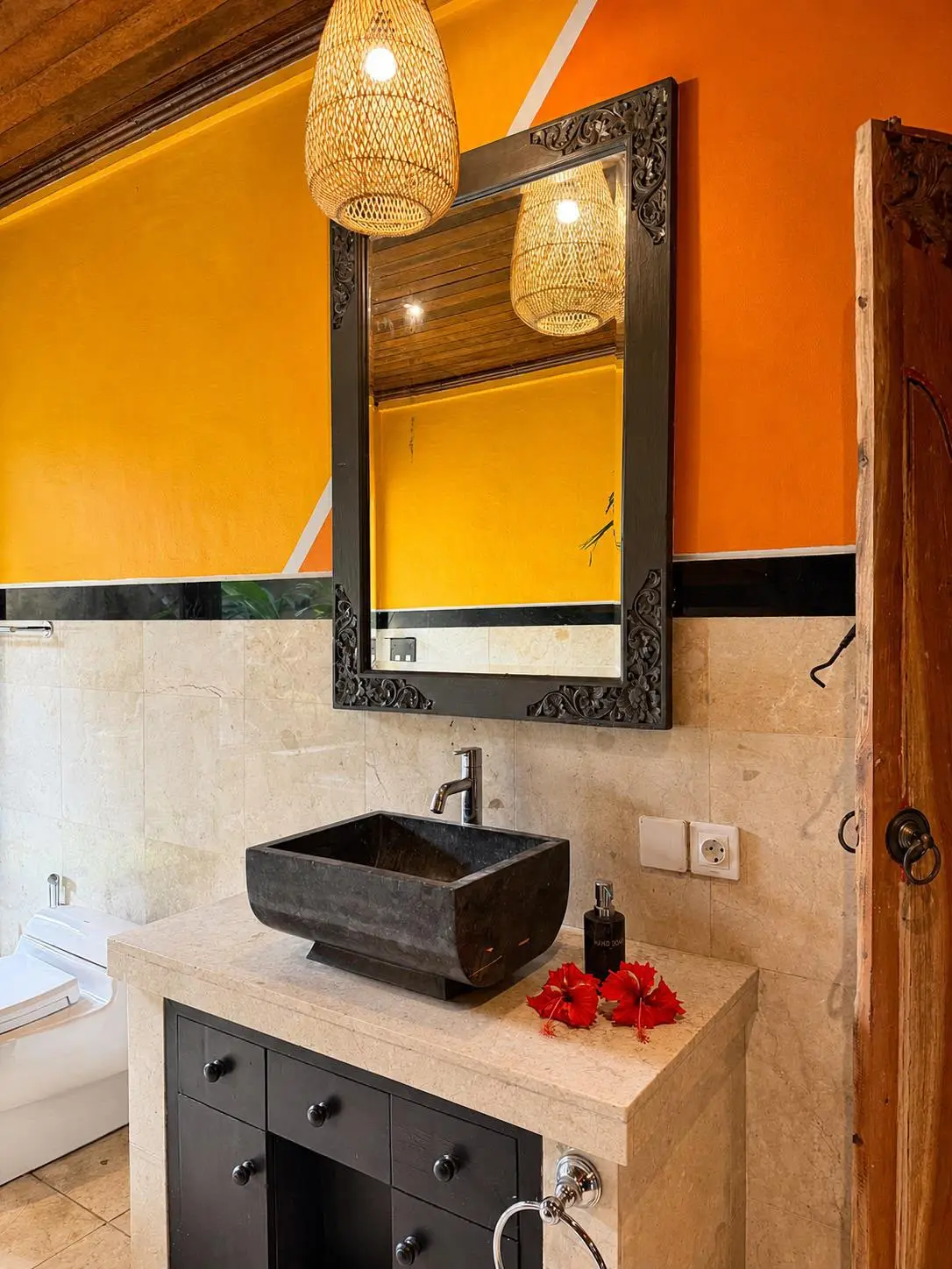 Bathroom with a stone sink and orange walls