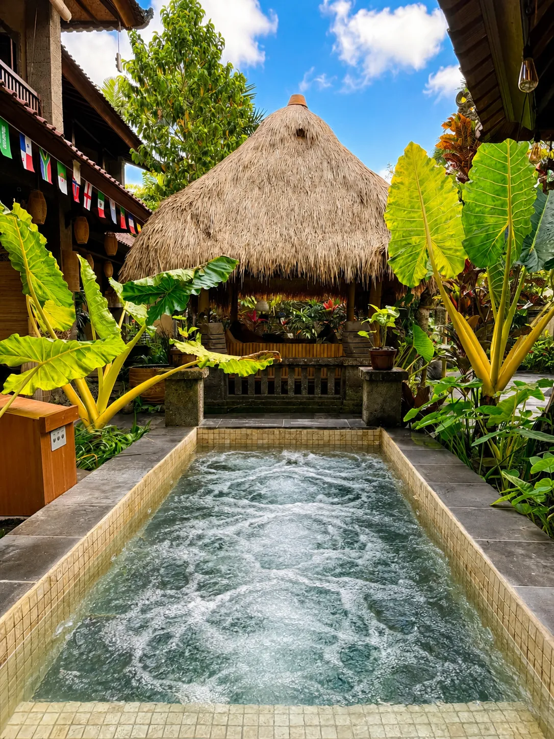 The jacuzzi, steaming, under the thatched roof